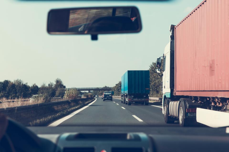 Udsigt gennem forruden fra en bil på motorvejen med lastbiler foran