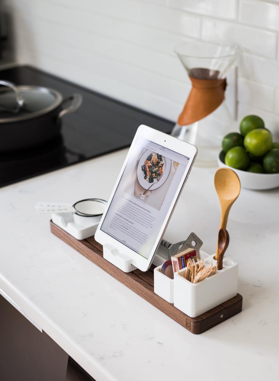 En tablet med en opskrift står i en holder på et køkkenbord