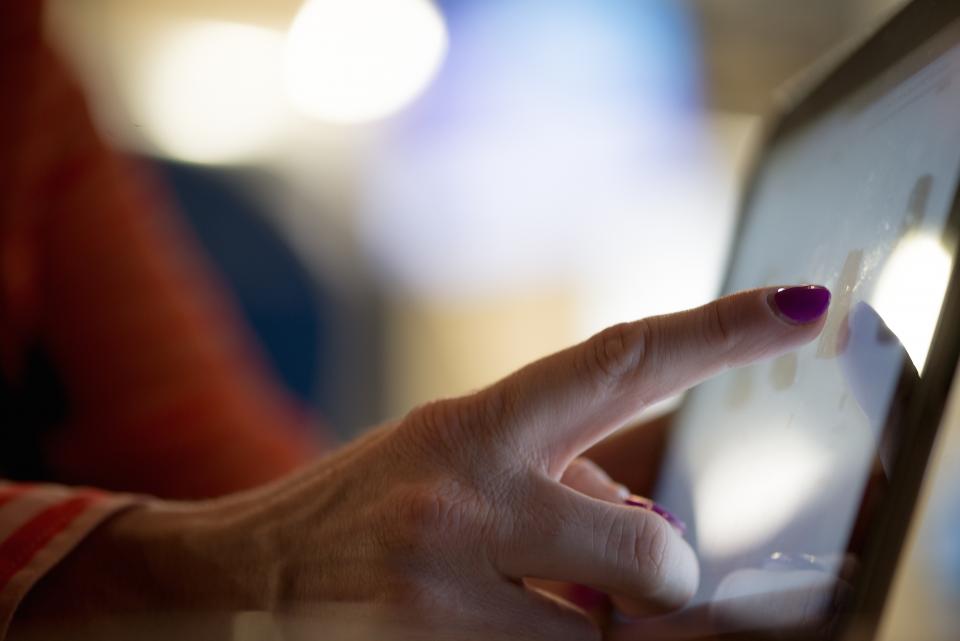 En finger rører skærmen på en tablet