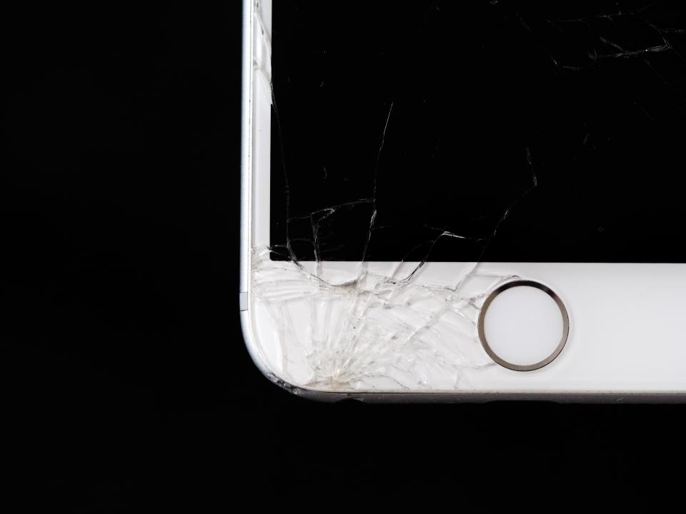 Et revnet glas i hjørnet af en hvid telefon